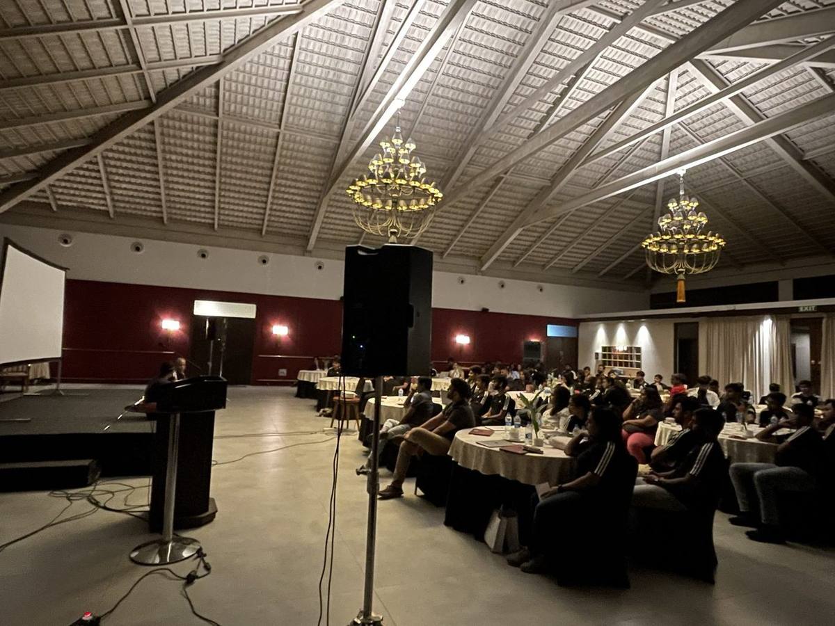 The whole company at round tables during an evening session with a guest speaker